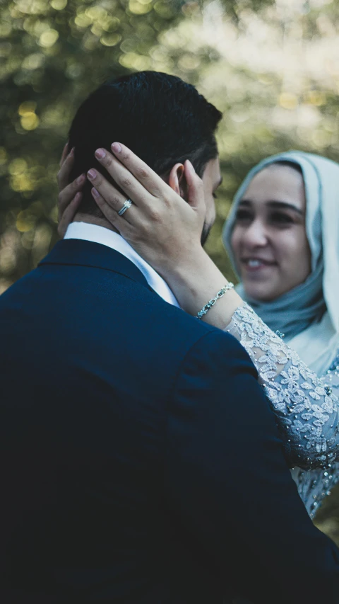 a man in a suit and a woman in a hijab, a colorized photo, trending on unsplash, hands in her hair, thumbnail, shot on sony a 7, wedding photo