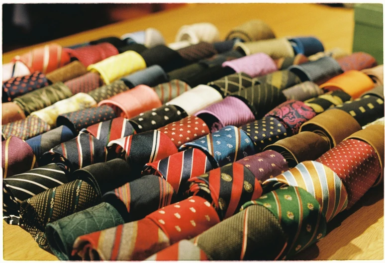 a wooden table topped with lots of different colored ties, flickr, renaissance, 1 9 8 0 s business fashion, postcard, black tie, 1999 photograph