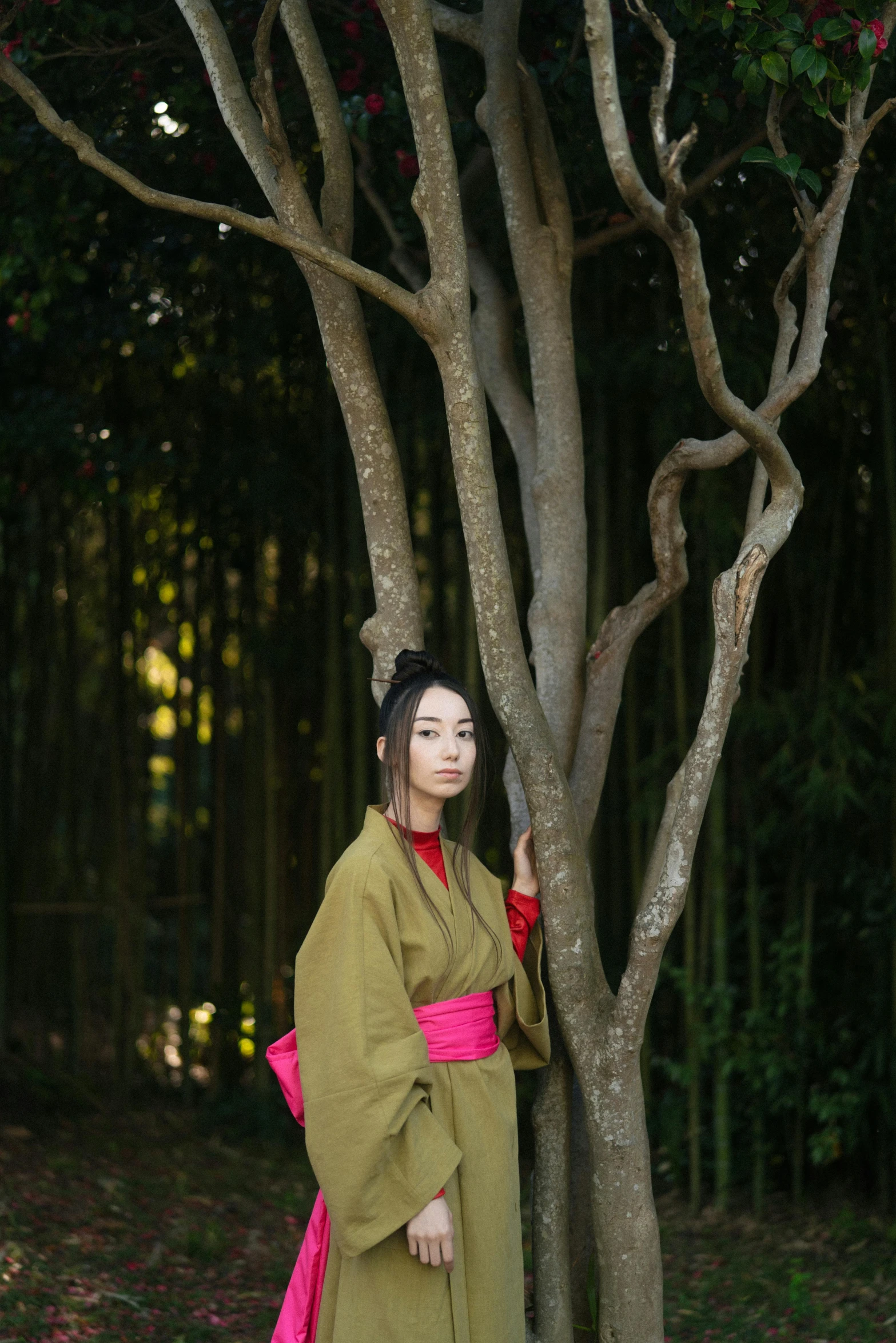 a woman standing next to a tree in a forest, inspired by Itō Shinsui, unsplash, made of bamboo, traditional costume, instagram photo, concept photo