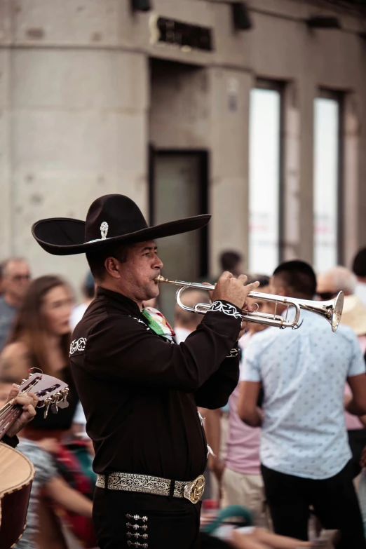 a man playing a trumpet in a crowd of people, by Alejandro Obregón, pexels contest winner, happening, mexican vaquero, square, seasonal, profile image