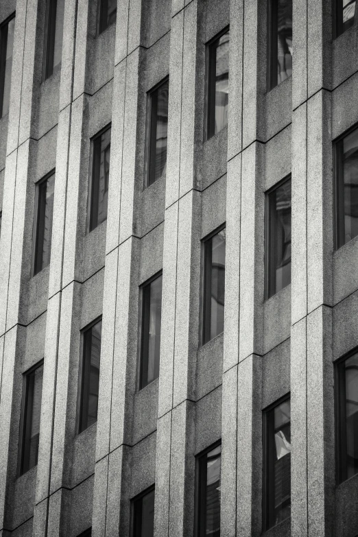 a black and white photo of a tall building, unsplash, brutalism, square shapes, window ( city ), grainy, windows