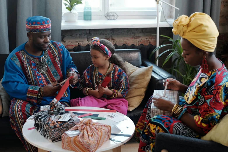 a group of people sitting on top of a couch, pexels contest winner, afrofuturism, somali attire, crafting, husband wife and son, video still