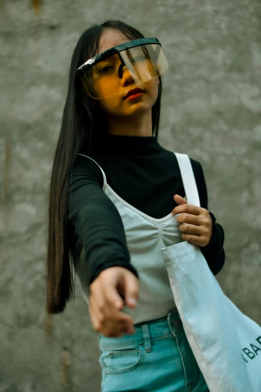 a woman wearing a protective face mask holding a bag, an album cover, inspired by Gao Cen, pexels contest winner, in a fighting stance, asian girl with long hair, 2019 trending photo, person made out of glass