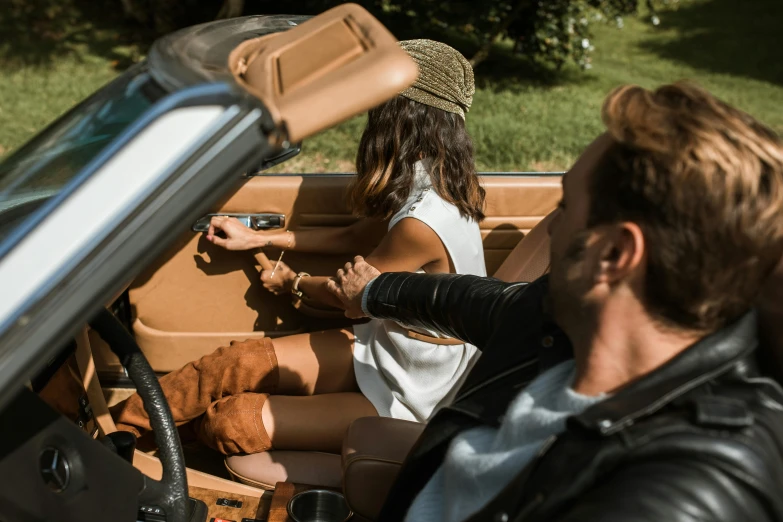 a man and a woman in a convertible car, trending on pexels, leather and suede, caramel. rugged, avatar image, sun drenched