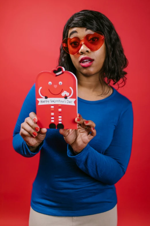 a woman in a blue shirt holding a red robot, an album cover, pexels contest winner, playing card suit hearts, red sunglasses, product introduction photo, holiday