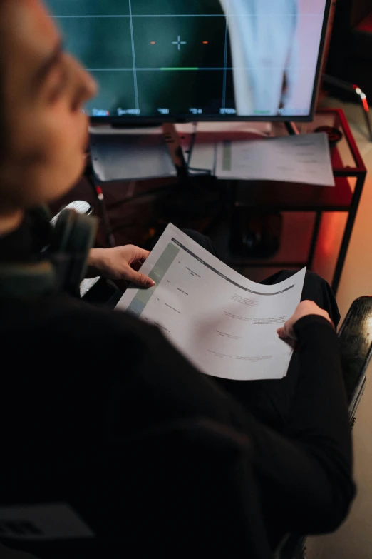 a man sitting in a chair in front of a computer, by Adam Marczyński, pexels contest winner, character sheets on table, close up to the screen, production photo, xqc