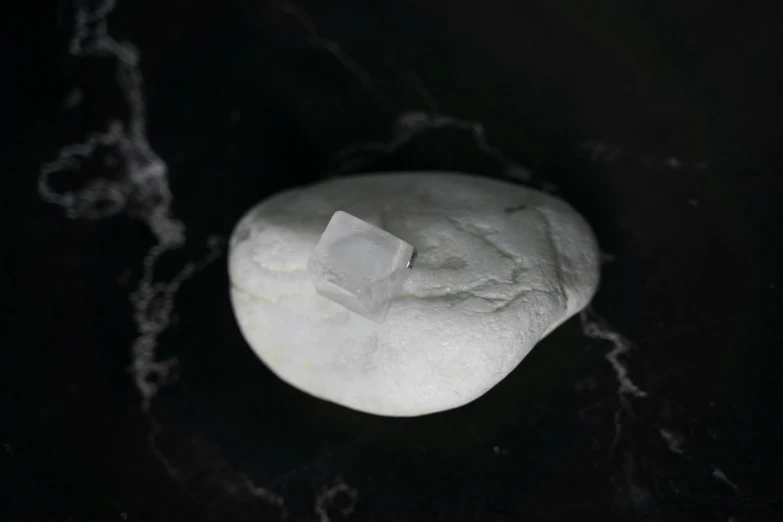 a rock with a piece of ice on top of it, inspired by Matteo Pérez, milk cubes, square, product shot, edible