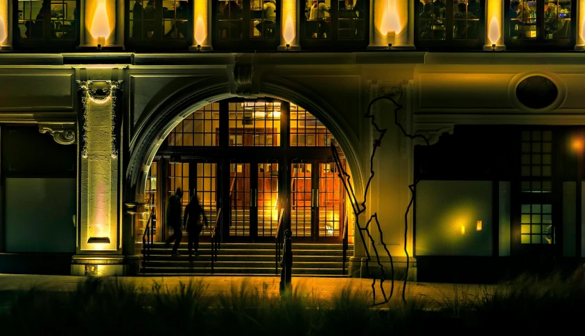 a couple of people that are standing in front of a building, by David Palumbo, pexels contest winner, art nouveau, enter night, archways made of lush greenery, yellow lighting from right, thumbnail