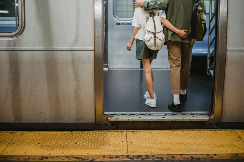 a man and a woman standing in the doorway of a train, trending on unsplash, new york streets, legs intertwined, ignant, bag over the waist