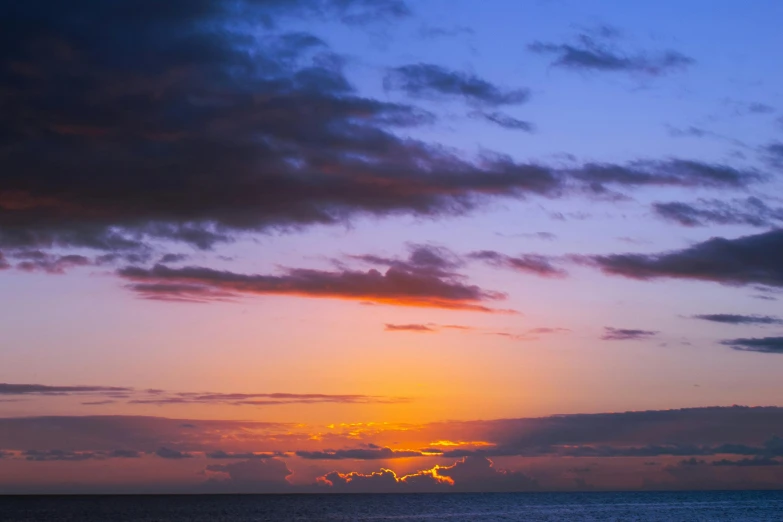 a couple of people standing on top of a beach next to the ocean, an album cover, unsplash, romanticism, orange clouds, reunion island, predawn, multicoloured