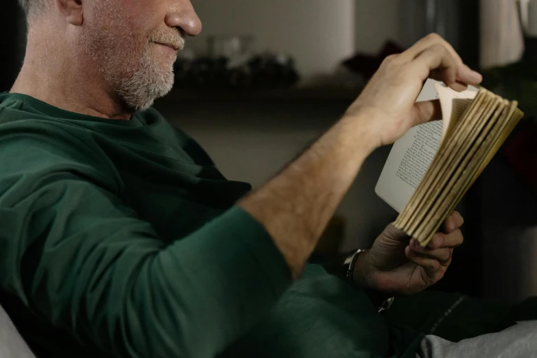 a man sitting on a couch reading a book, pexels contest winner, photorealism, older male, holding a wood piece, profile image, stacked image