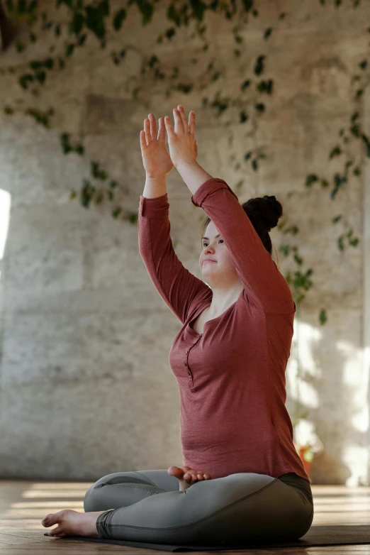 a woman sitting on the floor in a yoga pose, a picture, by Alison Watt, unsplash, renaissance, waving arms, plus size, with backdrop of natural light, maroon