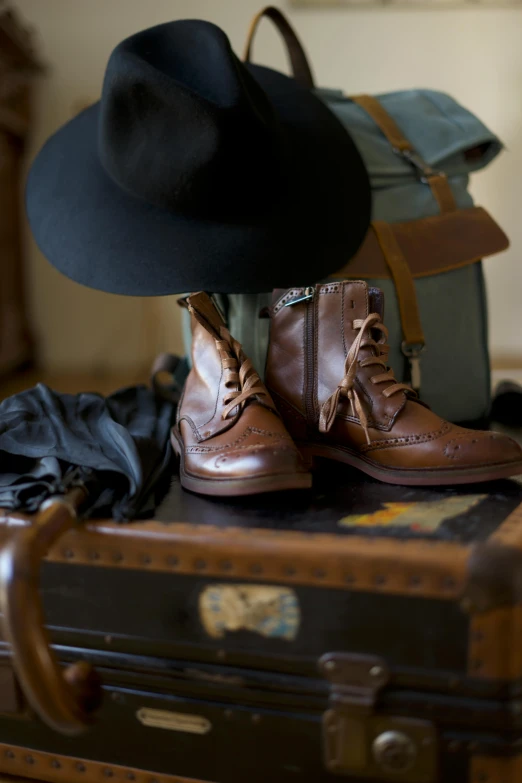 a hat is sitting on top of a suitcase, a portrait, by Jessie Algie, trending on unsplash, renaissance, military boots, avatar image