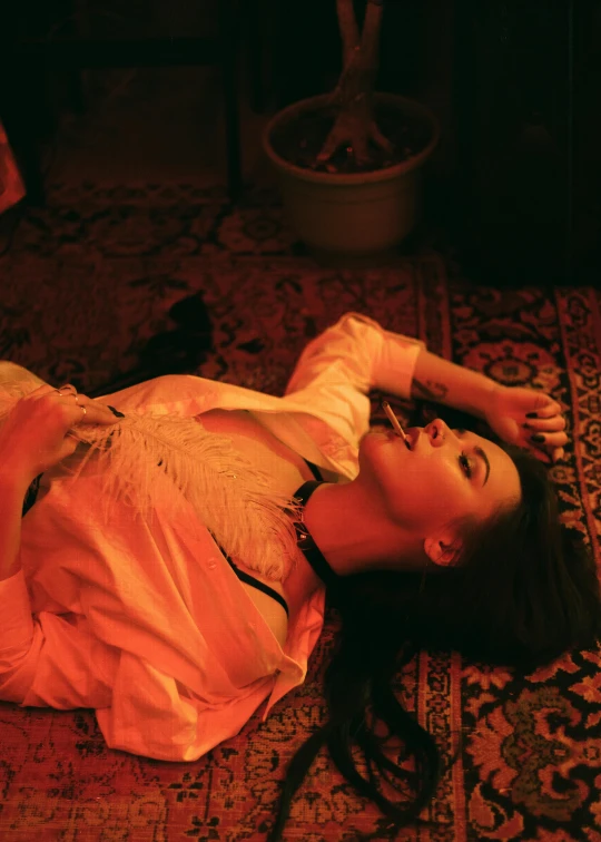 a woman laying on a rug in a room, an album cover, inspired by Elsa Bleda, renaissance, with red haze, **cinematic, drunk woman, perfectly lit. movie still