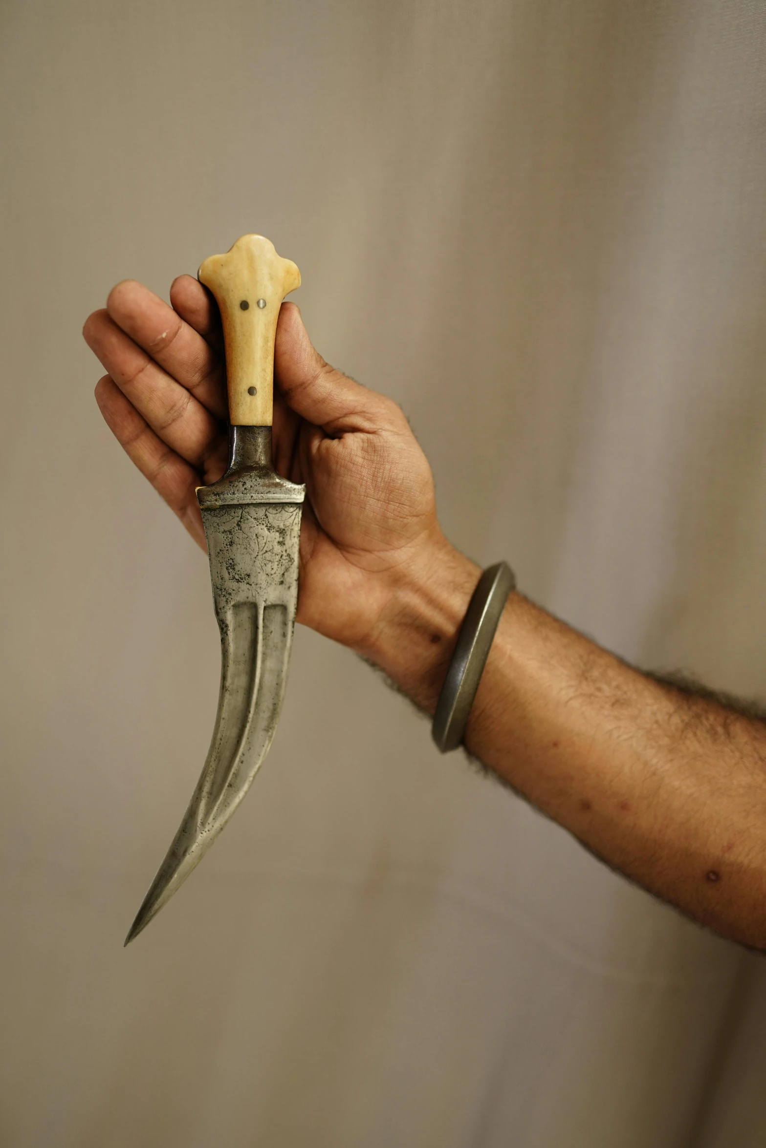 a person holding a knife in their hand, hurufiyya, slide show, decorative, grey, displayed