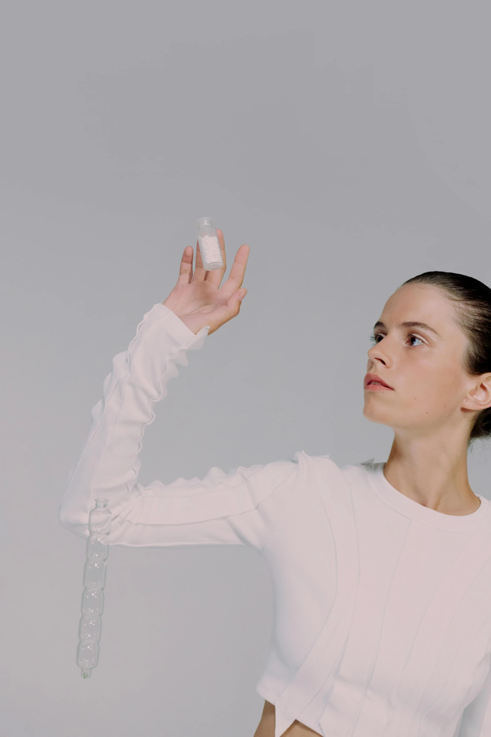 a woman holding a tennis racquet in one hand and a tennis ball in the other, an album cover, inspired by Marina Abramović, unsplash, bauhaus, transparent liquid, offering the viewer a pill, kaya scodelario, still frame