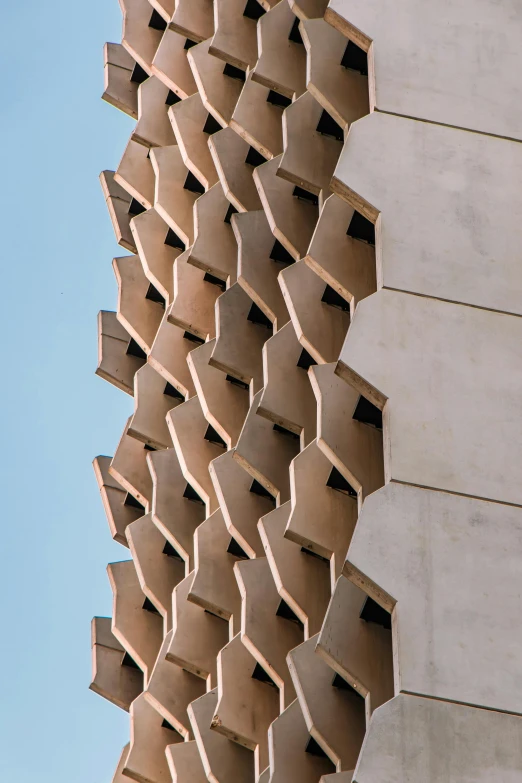 a close up of a building with a blue sky in the background, inspired by Zha Shibiao, brutalism, honeycomb, cardboard, close - up profile face, fins