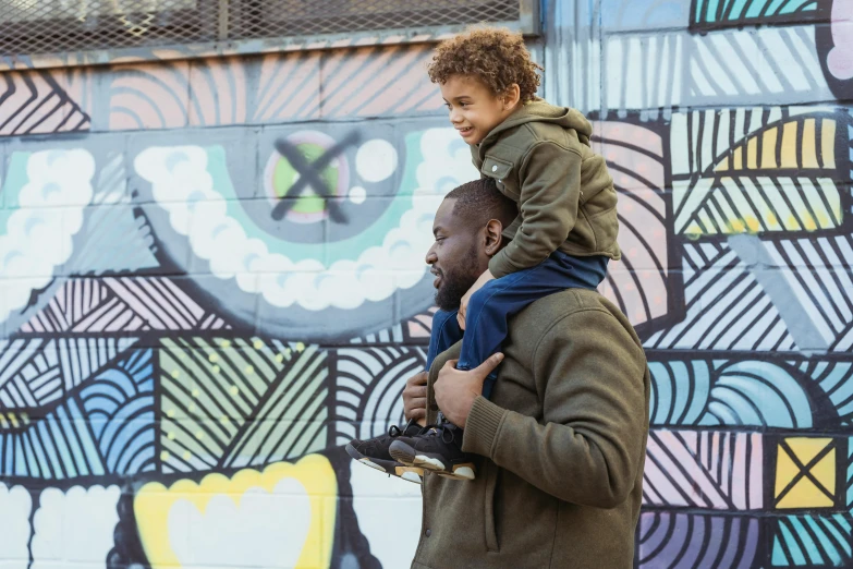 a man carrying a little boy on his shoulders, by Winona Nelson, pexels contest winner, symbolism, in an urban setting, kevin hart, dynamic movie still, multicoloured