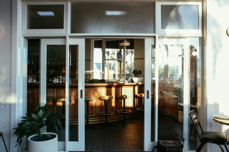 a view of a bar through a glass door, unsplash, art nouveau, manly, perfect crisp sunlight, wide windows, patio