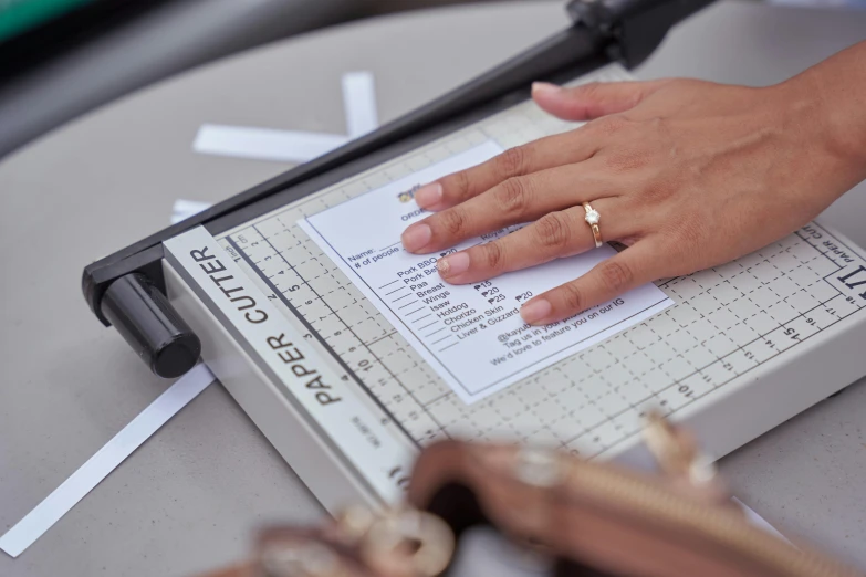 a person using a paper cutter to cut a piece of paper, by Julia Pishtar, on location, charts, wedding, information