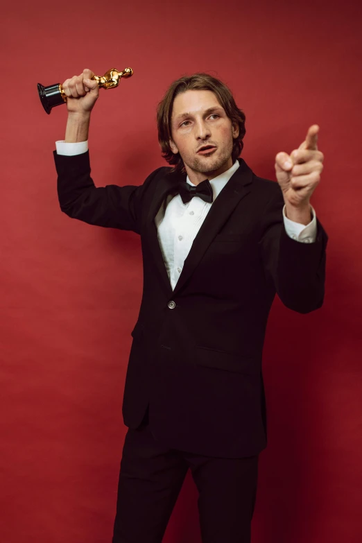 a man in a tuxedo holding an award, inspired by Sergei Sviatchenko, renaissance, adam driver, award winning press photo, tom hardy, champagne commercial