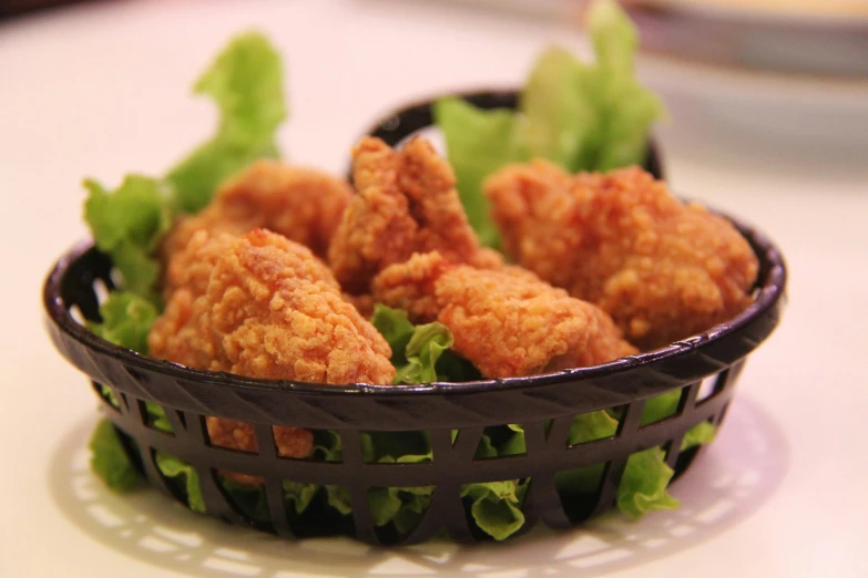 a basket filled with fried chicken next to lettuce, pixabay, hurufiyya, shot on sony a 7, rabbit ears, medium close up shot, each having six wings