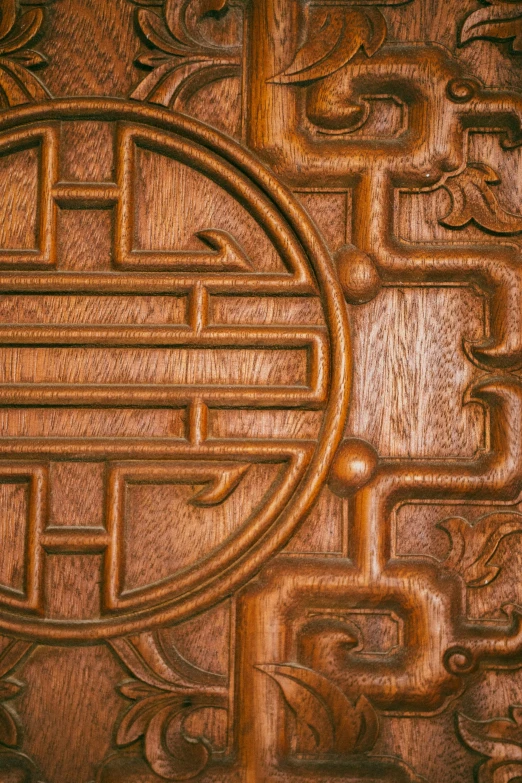 a wooden panel with a circular design on it, inspired by Sesshū Tōyō, trending on unsplash, closeup of arms, cartouche, qi sheng luo, 2010s