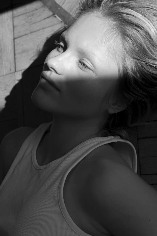 a black and white photo of a woman, inspired by Max Dupain, photorealism, the girl and the sun, kate moss, face is brightly lit, innocence