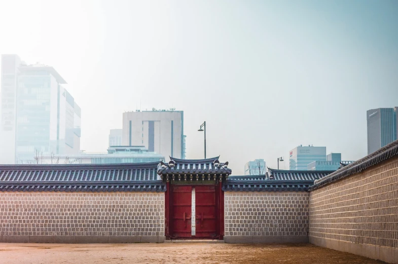 a red door sitting in the middle of a courtyard, by Simon Gaon, towering over a city, traditional korean city, unsplash photography, square