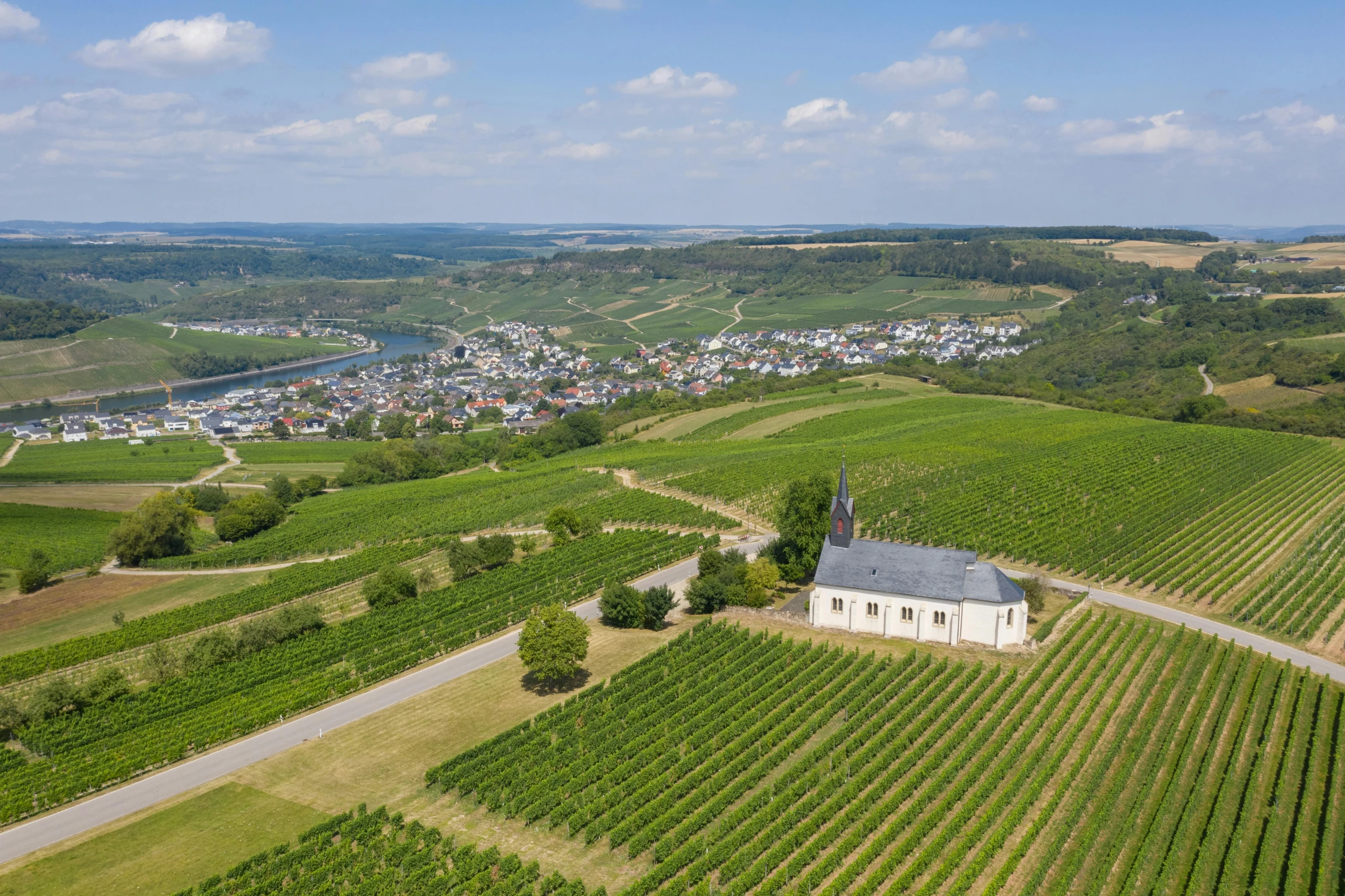 a small church sitting on top of a lush green field, by Breyten Breytenbach, les nabis, wine, overview, white