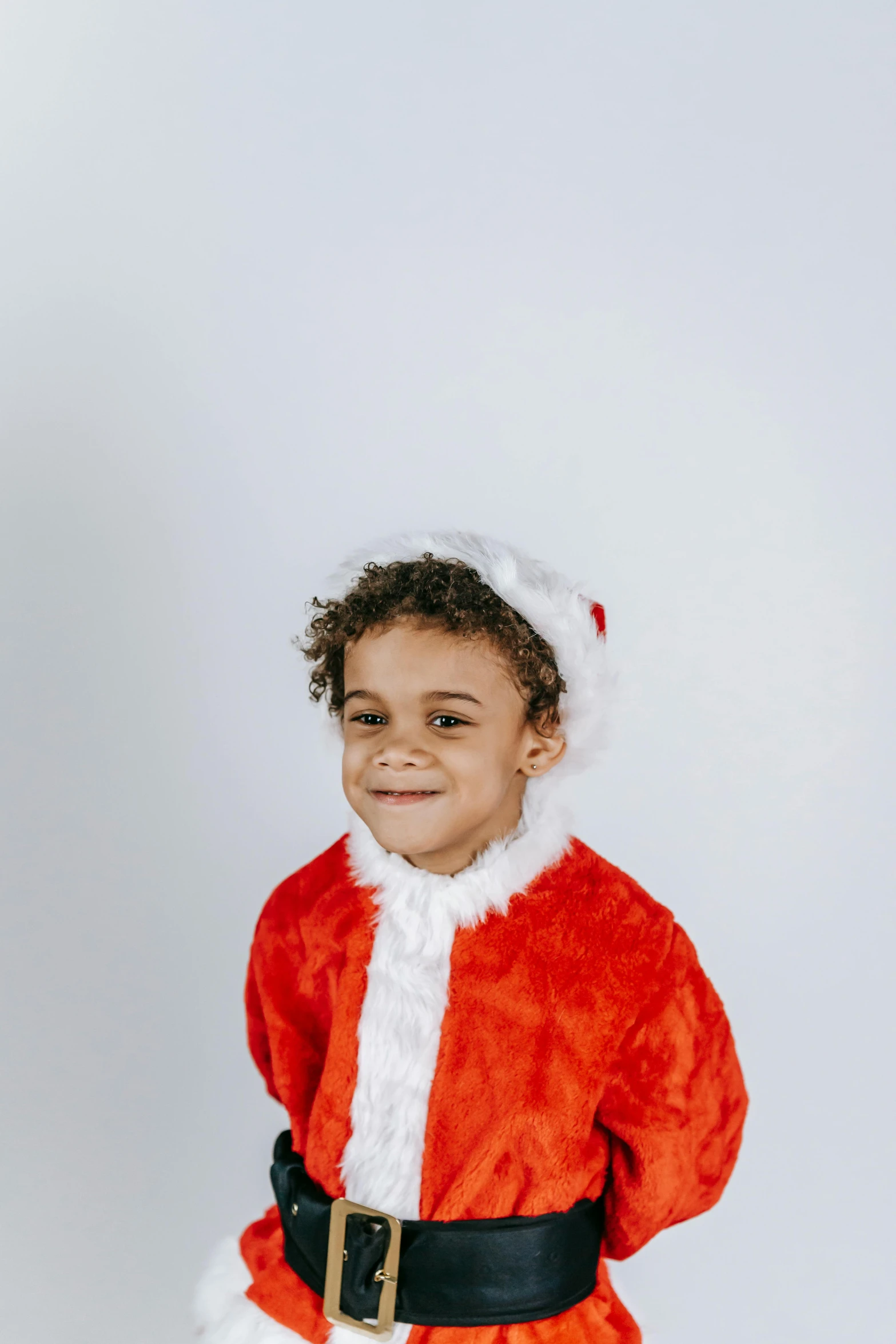 a little boy dressed up as santa claus, an album cover, pexels, diverse, 4yr old, plain background, 8