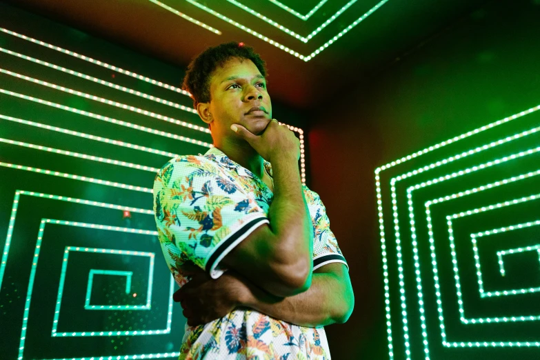 a man standing in front of a neon wall, an album cover, by David Brewster, patterned clothing, looking away from camera, tyler, gallant