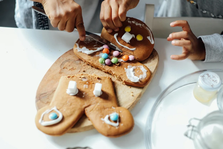 a couple of people that are decorating some cookies, by Julia Pishtar, pexels contest winner, cut-away, ginger, tabletop, kids