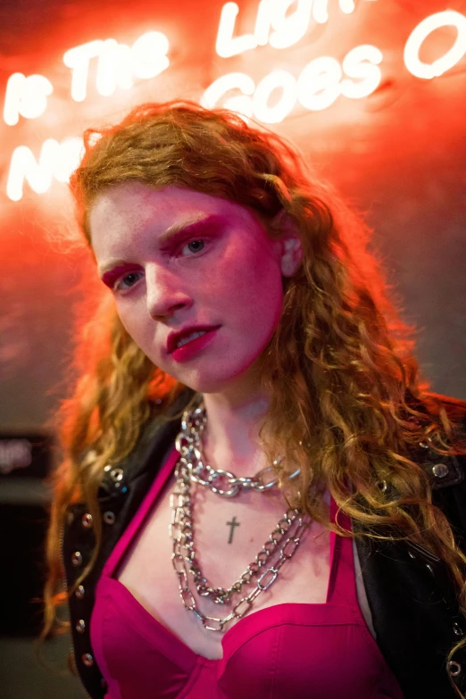 a woman standing in front of a neon sign, an album cover, inspired by Nan Goldin, renaissance, looks like a mix of grimes, piercings collar, hr ginger, trending photo