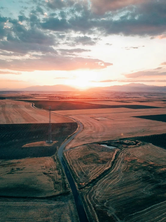 an aerial view of the sun setting over farmland, unsplash contest winner, instagram post 4k, high quality product image”, bird\'s eye view, valley in the distance