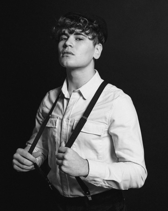 a black and white photo of a man wearing suspenders, unsplash, bauhaus, declan mckenna, joe keery, profile picture, non binary model