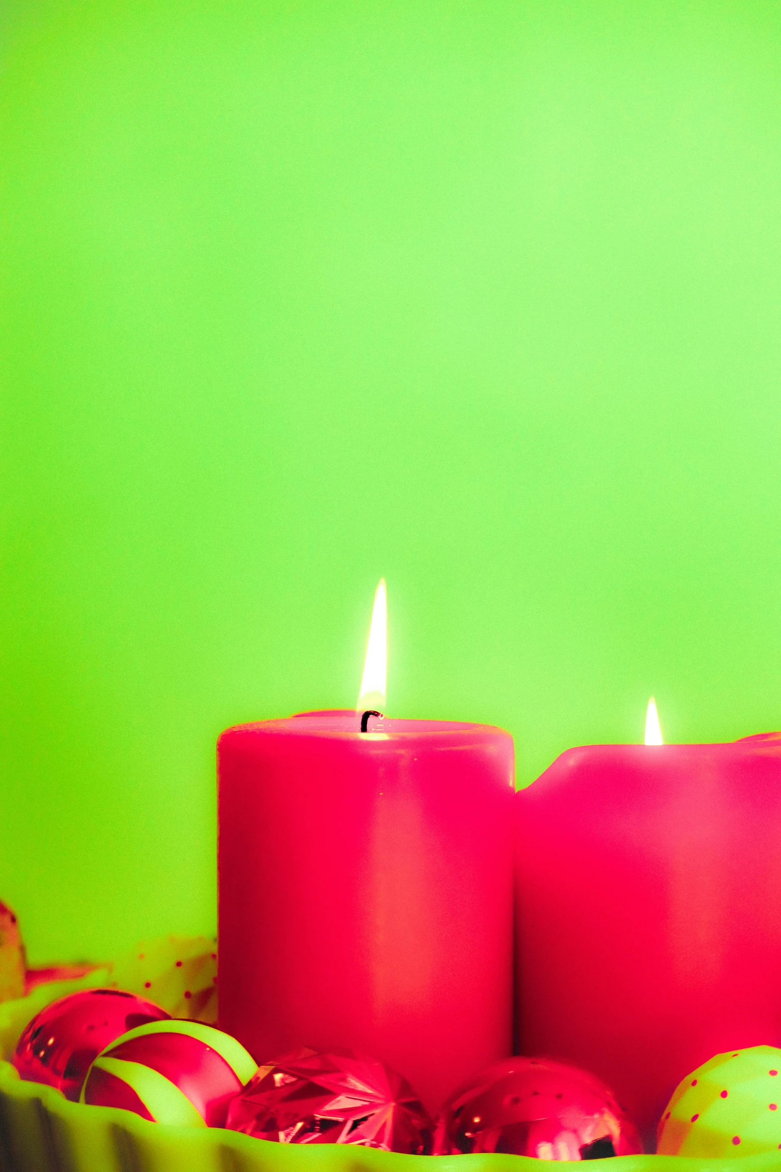 a group of red candles sitting on top of a table, an album cover, pexels, minimalism, pink and green, holiday, dayglo, bright vibrant color