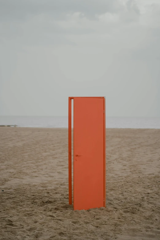 an orange door sitting on top of a sandy beach, a minimalist painting, by Attila Meszlenyi, unsplash, cube portals, upright, brown, tall