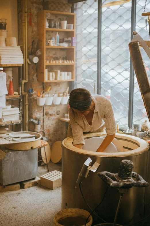 a woman is working in a pottery shop, by Jessie Algie, trending on unsplash, process art, japanese bathhouse, inside a grand studio, dwell, small manufacture