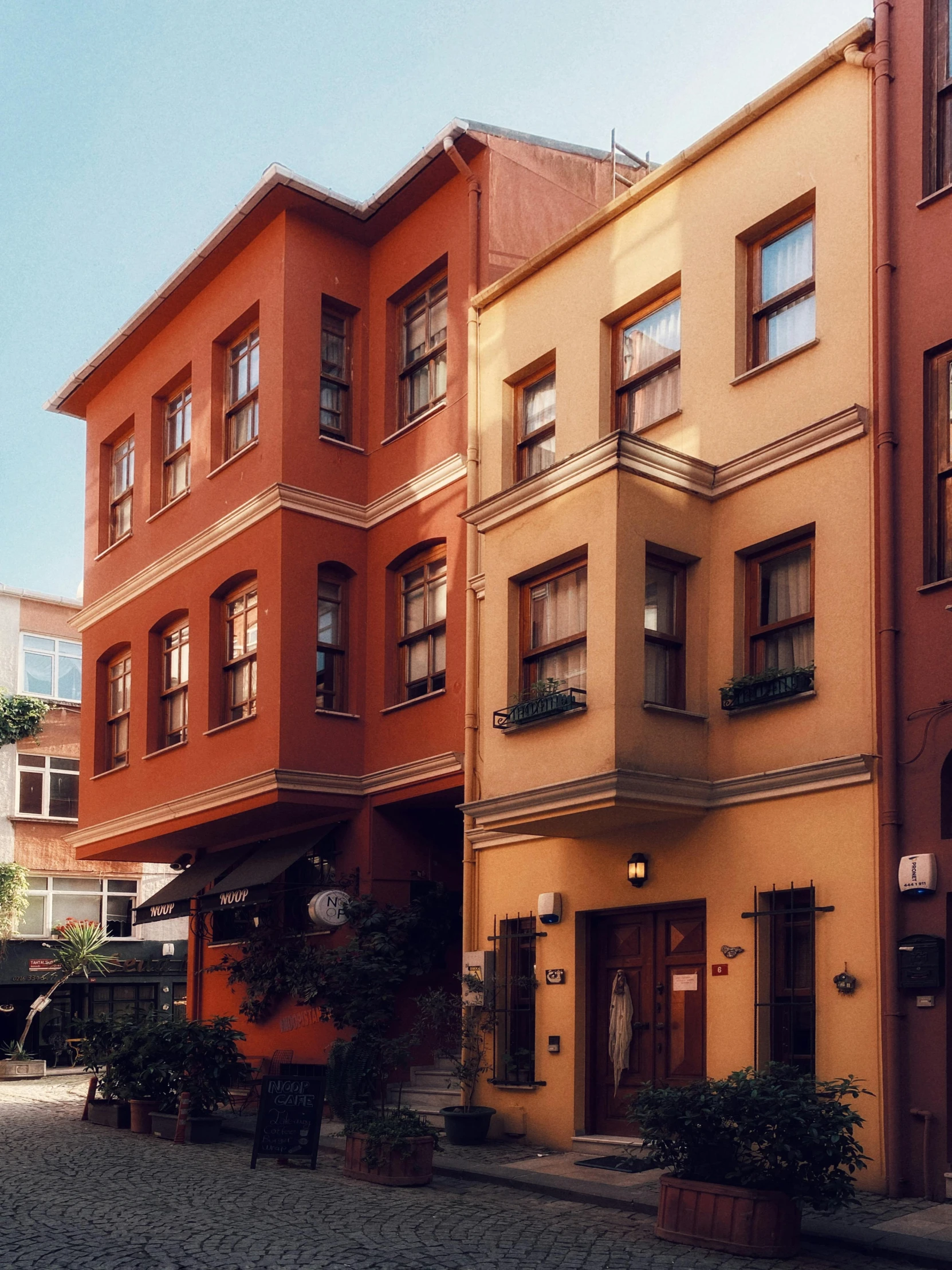 a couple of buildings that are next to each other, a photo, inspired by Niyazi Selimoglu, art nouveau, ektachrome color photograph, brown, hotel, yard