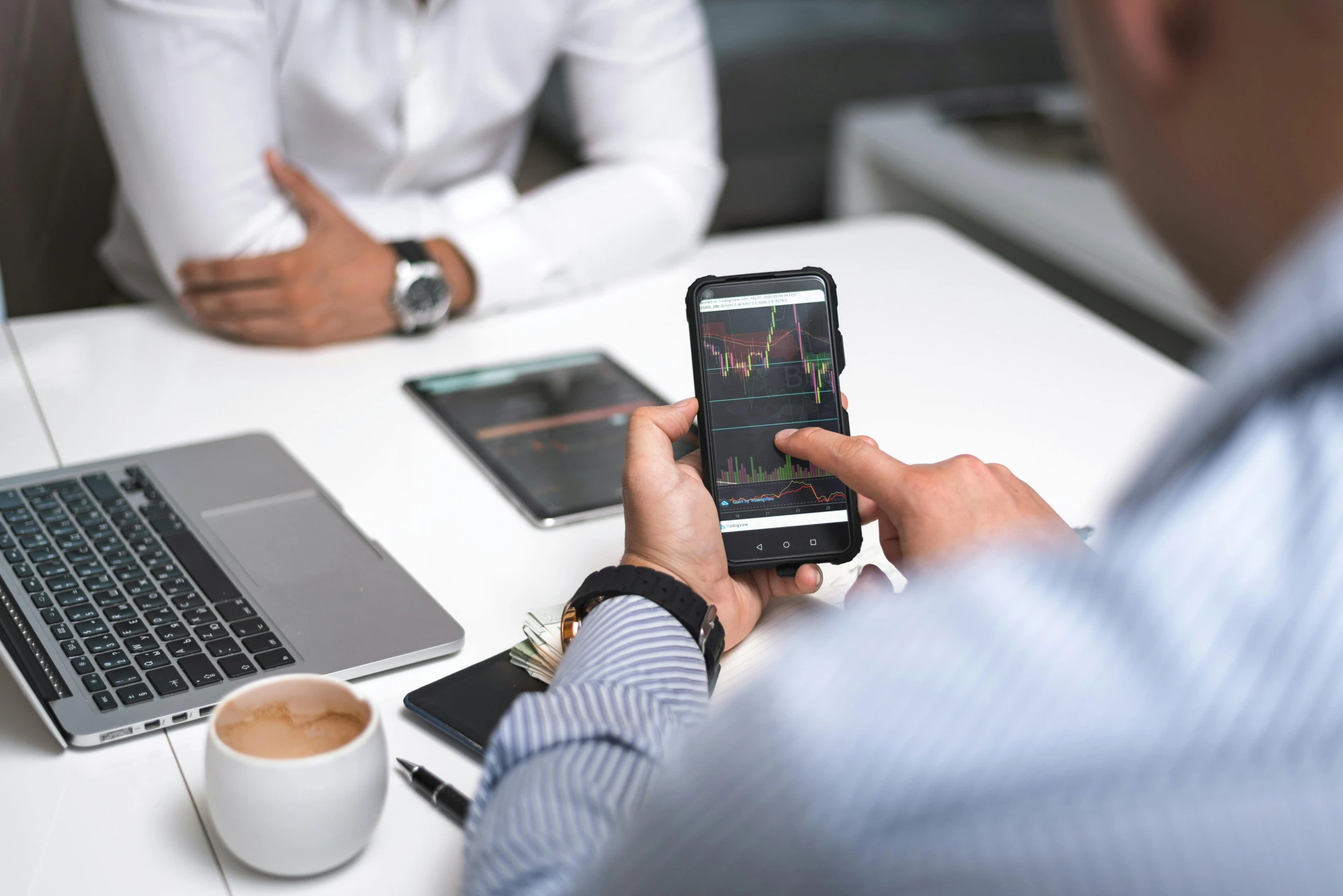 two men sitting at a table with laptops and cell phones, a picture, by Adam Marczyński, pexels, renaissance, waveforms on top of square chart, corporate phone app icon, square, looking across the shoulder