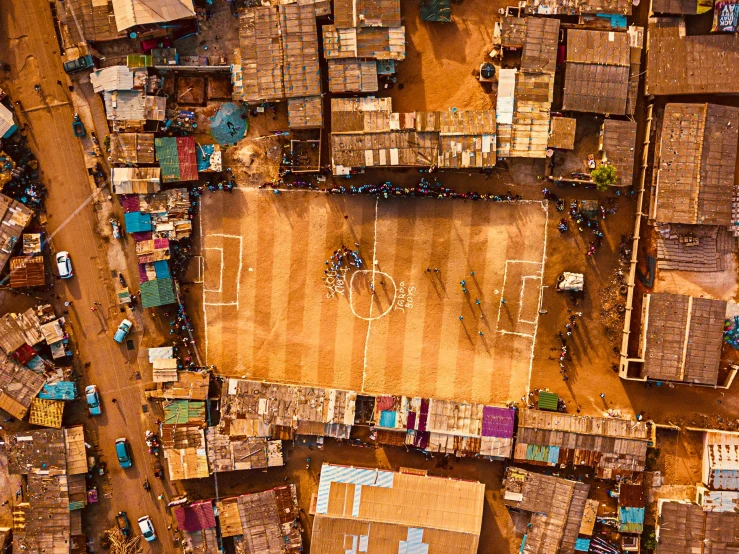 an aerial view of a basketball court surrounded by buildings, by Daniel Lieske, pexels contest winner, unmistakably kenyan, shanty town, soccer stadium, celebrating