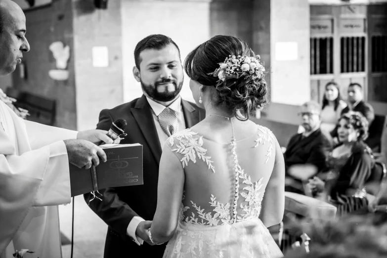 a man standing next to a woman in a wedding dress, a black and white photo, by Romain brook, edu souza, ceremony, looking content, uploaded