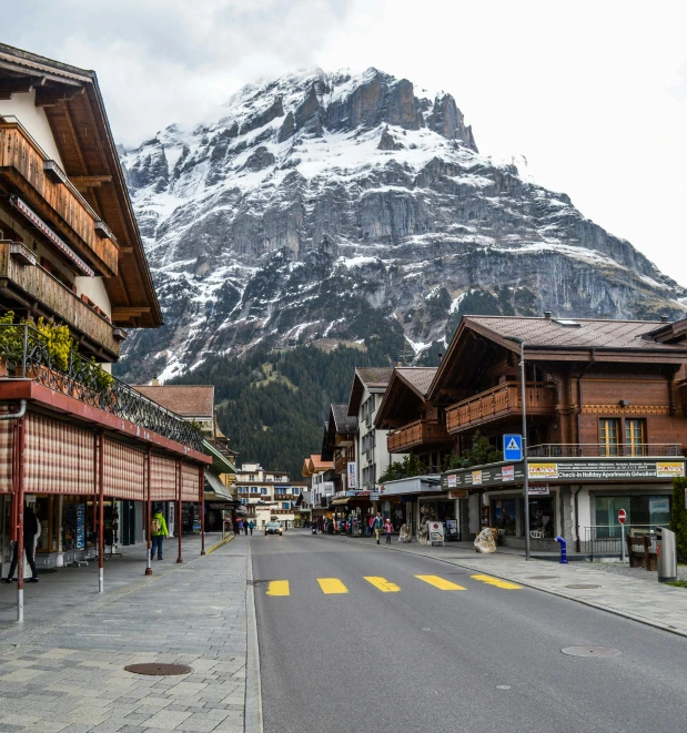 a street with a mountain in the background, swiss architecture, slide show, fan favorite, lots of shops