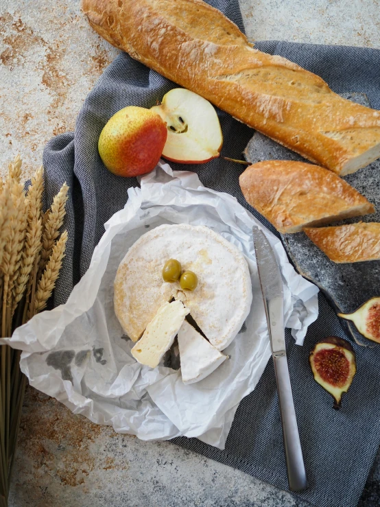 a table topped with bread, fruit and breadsticks, product image, fan favorite, eating cheese, on high-quality paper