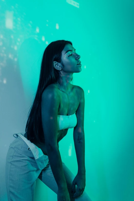 a woman in a white top and white pants, inspired by Elsa Bleda, trending on pexels, art photography, teal neon lights, ((greenish blue tones)), coloured gel studio light, madison beer