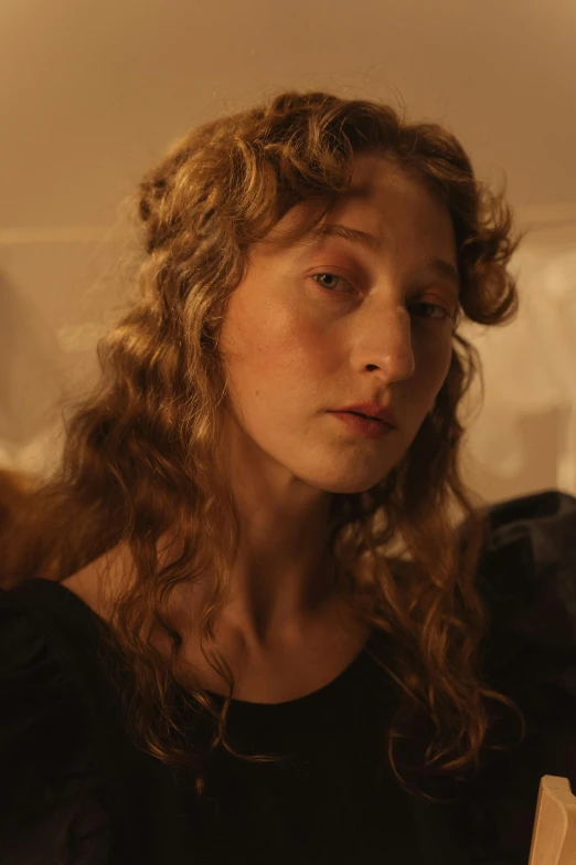 a woman sitting on a bed reading a book, an album cover, inspired by Jan Lievens, unsplash, renaissance, her face framed with curls, perfectly lit. movie still, movie scene close up, ( ( theatrical ) )