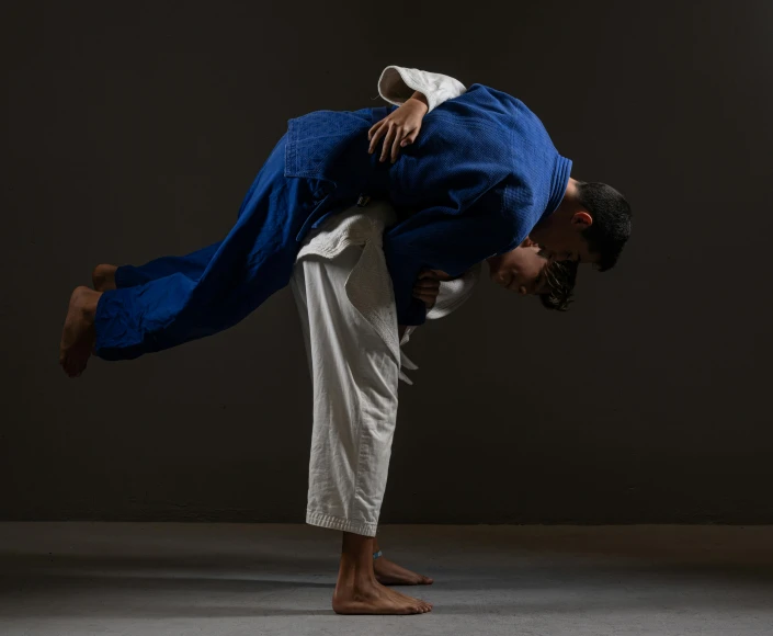 a man in a blue suit doing a handstand, unsplash, figuration libre, karate outfit, two men hugging, wearing a blue robe, wrestling