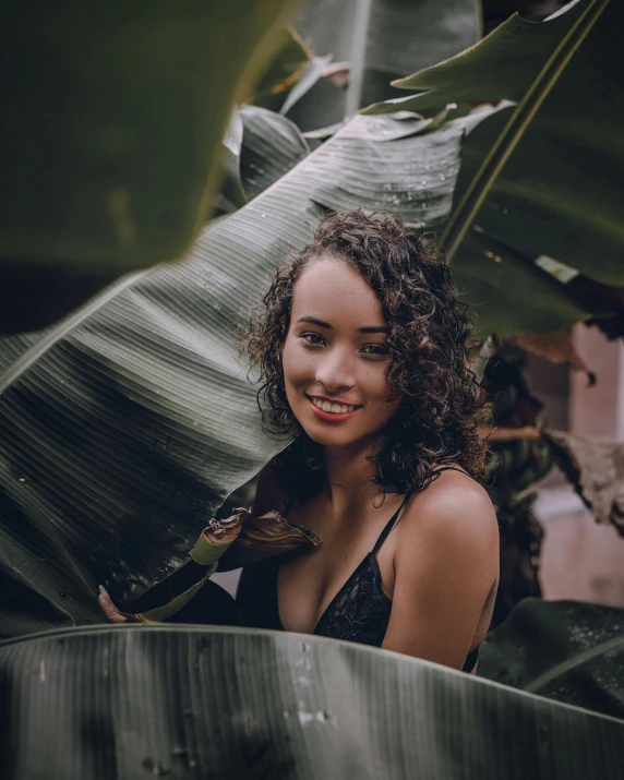 a woman sitting on top of a banana tree, pexels contest winner, dark short curly hair smiling, portrait sophie mudd, with textured hair and skin, (tropicalism)