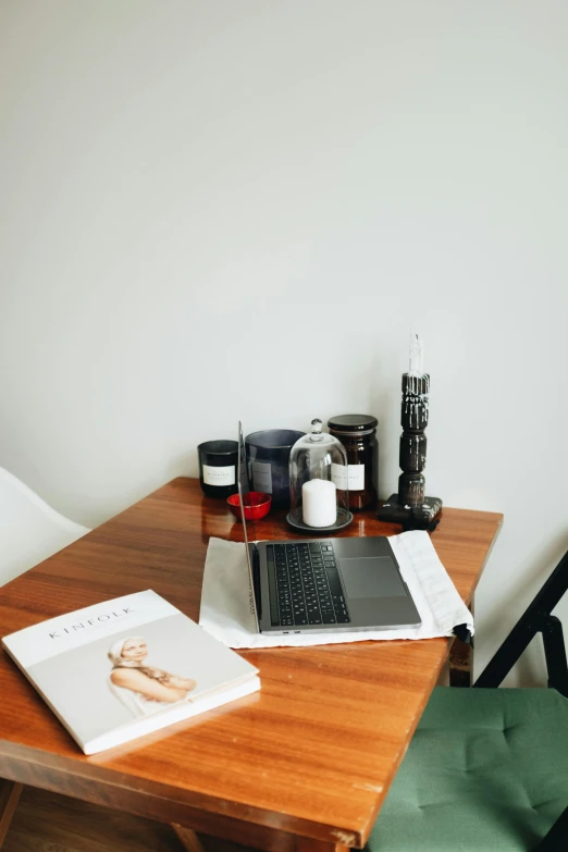 a laptop computer sitting on top of a wooden desk, various items, on a white table, dwell, oils